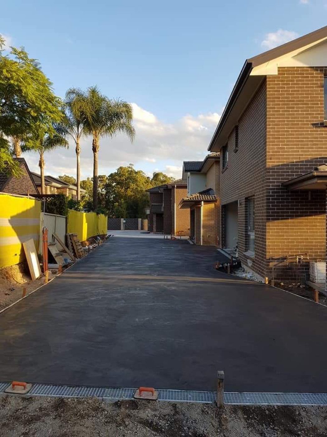 Freshly poured commercial concrete access driveway between Sydney unit blocks