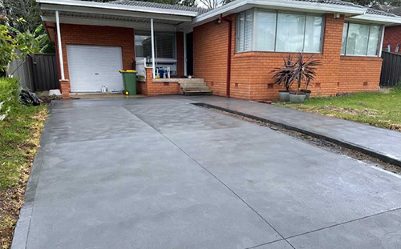 Finished plain concrete driveway to a brick home in Northmead, Sydney