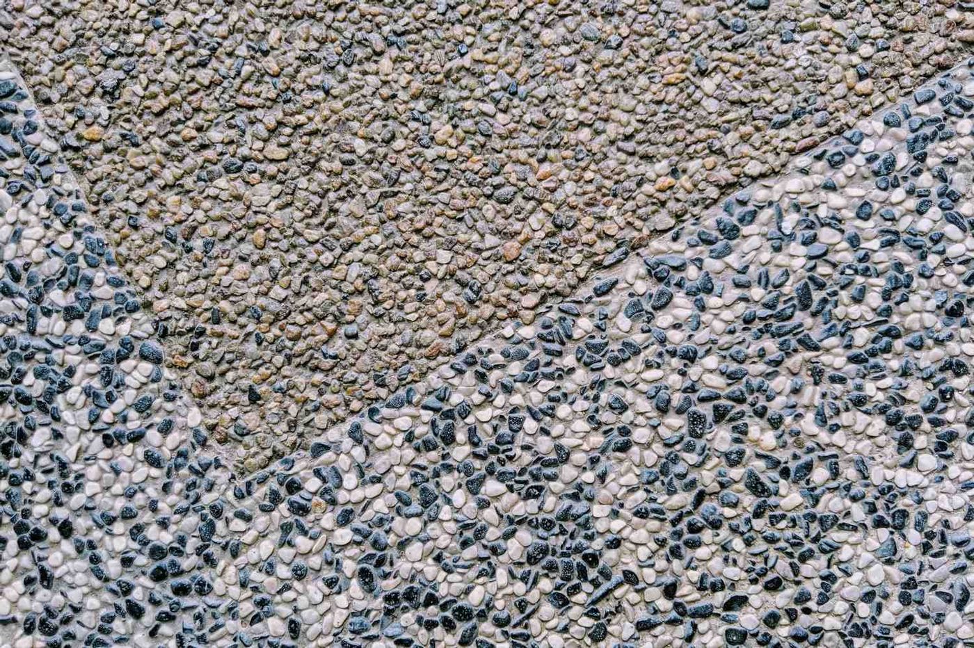 Close-up of exposed aggregate concrete showing natural stones and pebbles in the surface